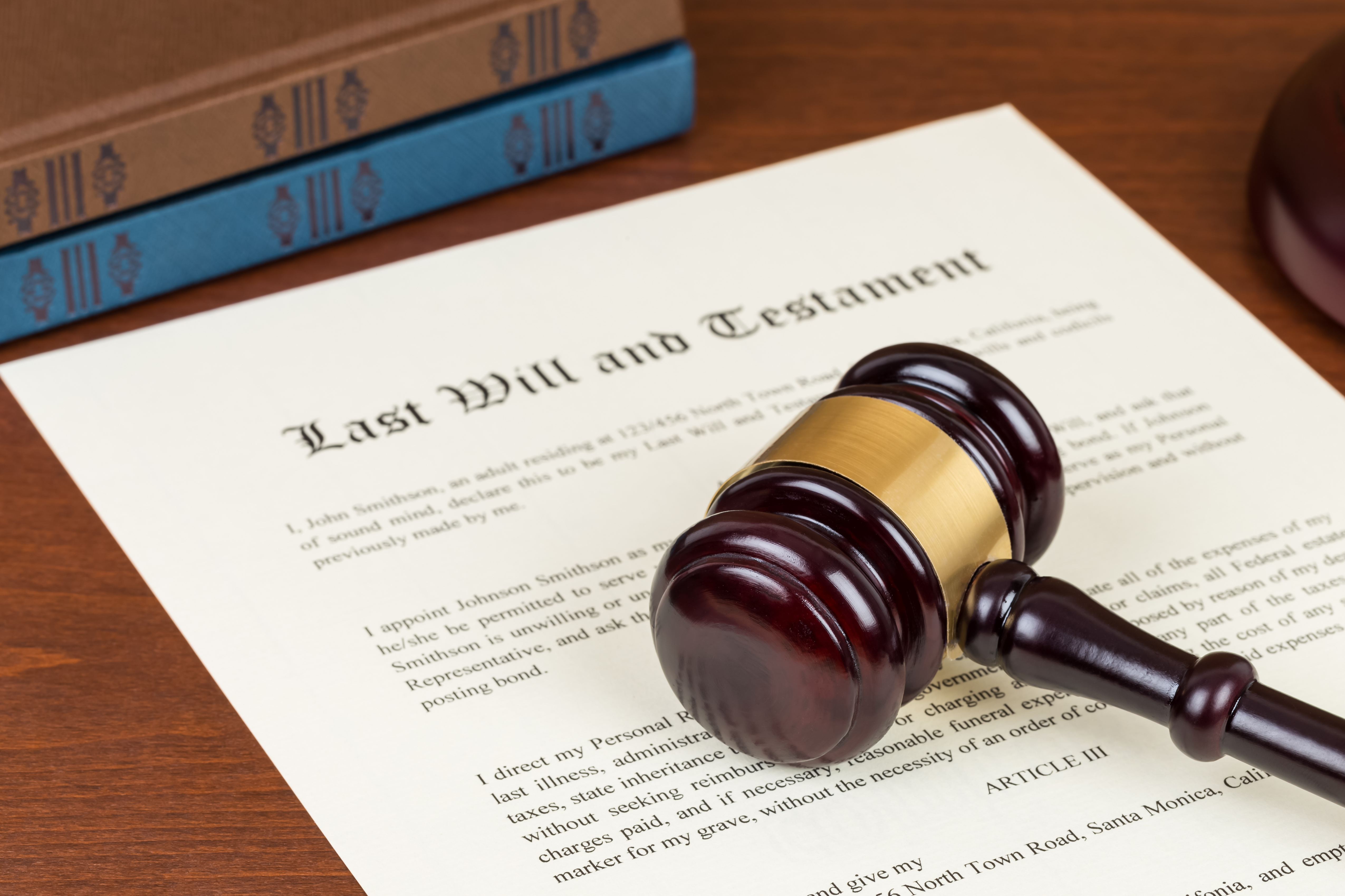 Last will and testament with wooden judge gavel; document is mock-up not real Last will and testament with wooden judge gavel; document is mock-up not real