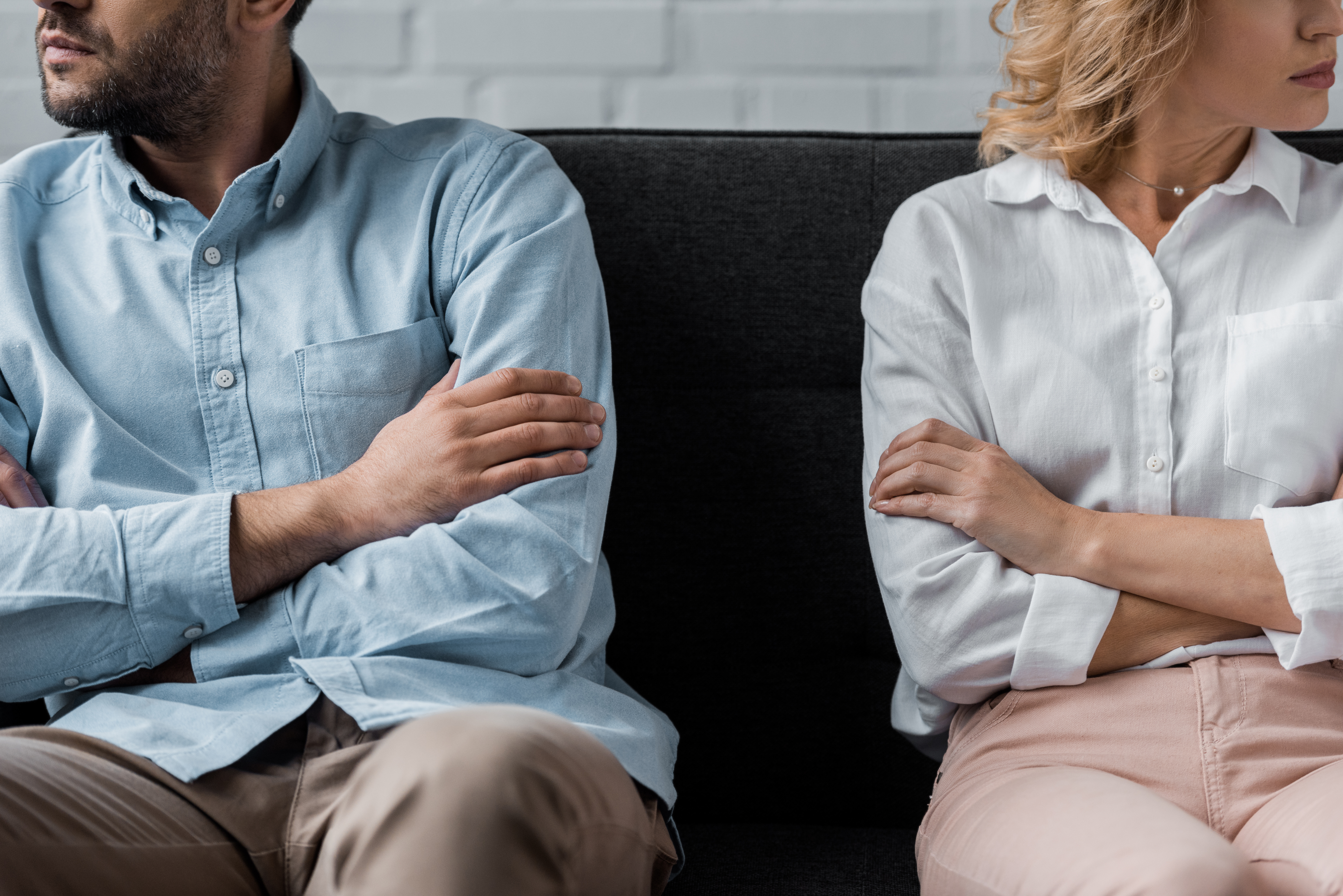 cropped shot of couple sitting on couch after quarrel cropped shot of couple sitting on couch after quarrel