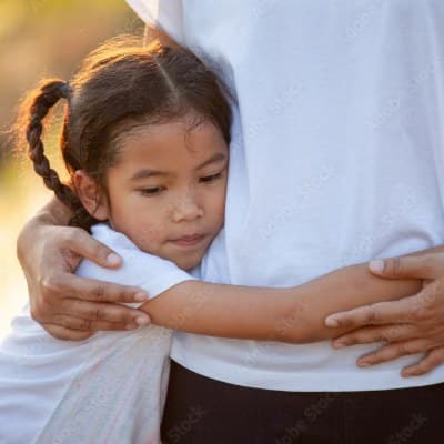 Young girl hugging a parent