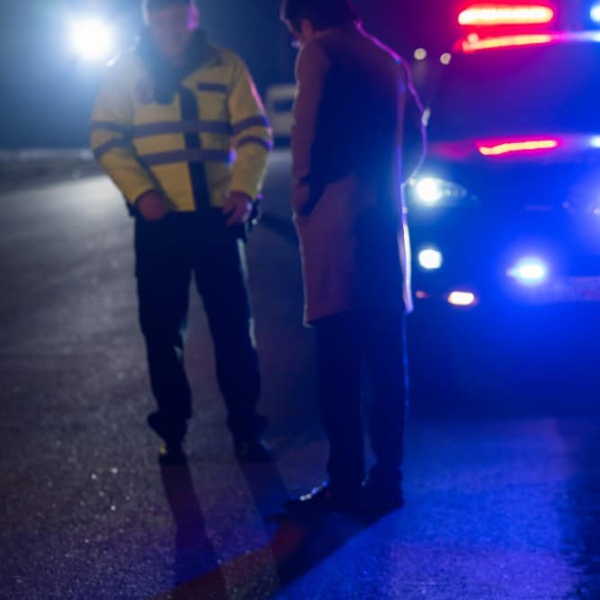 Police officer and driver at a nighttime DUI traffic stop